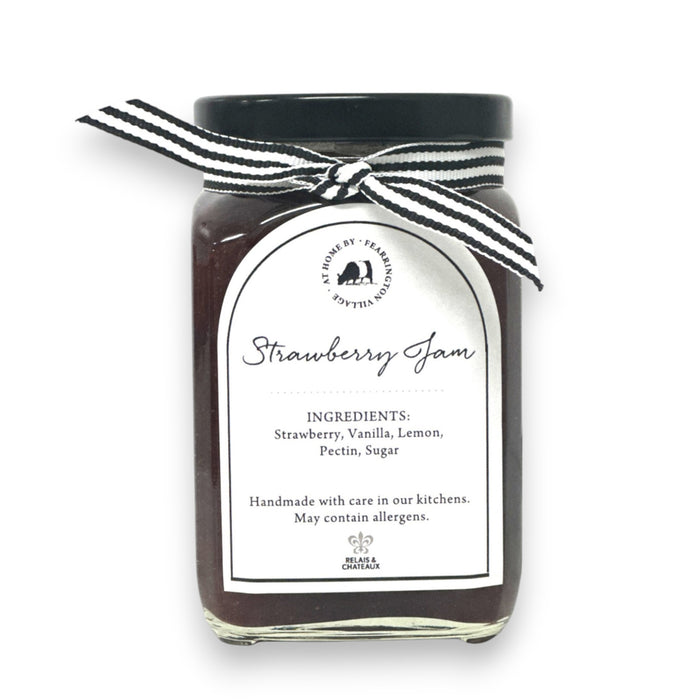 Introducing the FEARRINGTON HOUSEMADE STRAWBERRY JAM from the FEARRINGTON SIGNATURE COLLECTION, this jar of delicious strawberry jam is adorned with a charming black and white striped ribbon tied around the lid. Perfect as a hostess gift, its label lists wholesome ingredients such as strawberry, vanilla, lemon, pectin, and sugar. This handmade treat may contain allergens and is a delightful choice for breakfast jam enthusiasts.