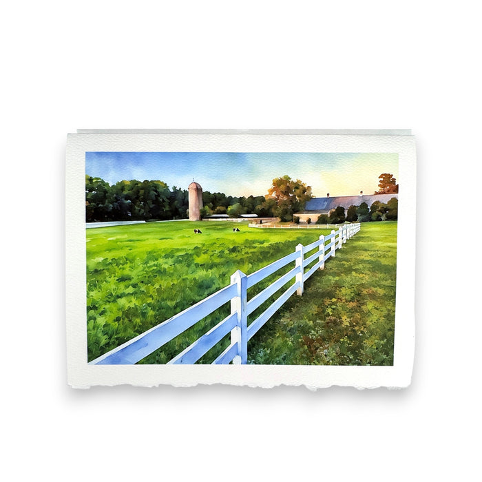 The FEARRINGTON SIGNATURE COLLECTION - WATERCOLOR GREETING CARD "AFTER SUNRISE" by PICTURE SALON features a farm scene with cows, barn, silo, and white fence—printed on premium cardstock for a stunning greeting.