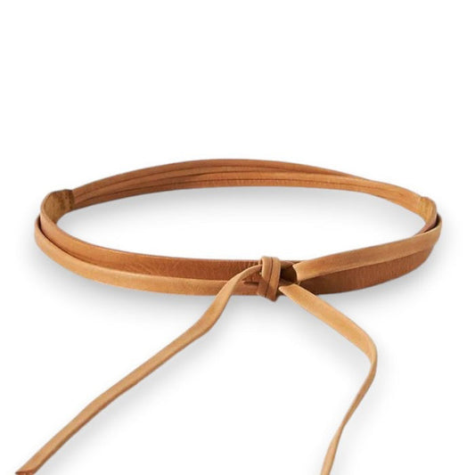 The ADA - SKINNY WRAP BELT by ADA is a thin, light brown leather belt made from natural material. It features a simple front knot and has adjustable ends that hang down, shown laid flat on a white background.