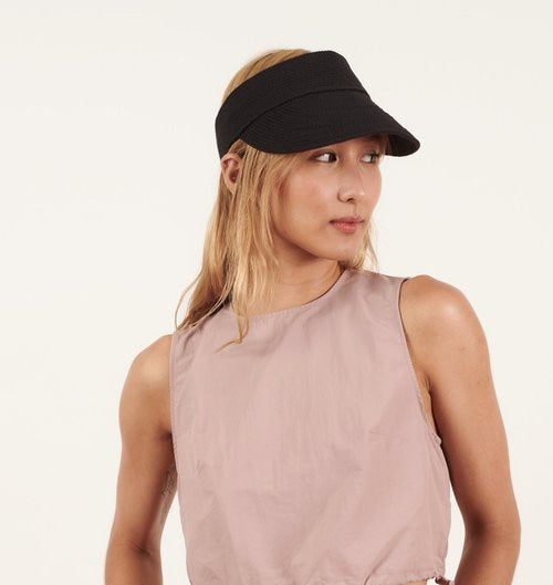 A woman with long, light brown hair wears the BEACH HARE - JUNIE VISOR by BEACH HARE and a mauve sleeveless top, looking to her right against a plain light background. The visor is handmade in NY.
