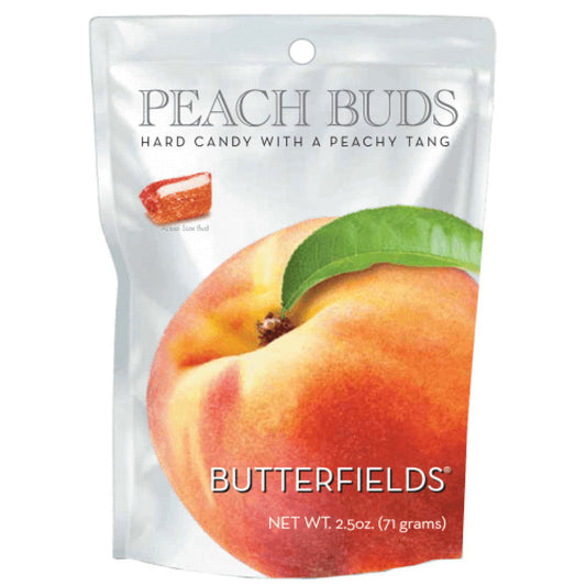 A round tin with a lid featuring a watercolor illustration of a peach. The tin, labeled "BUTTERFIELDS - PEACH BUDS," displays two halves of a peach, one with a pit. Treat yourself to this delightful hard candy, proudly made in the United States by Butterfields.