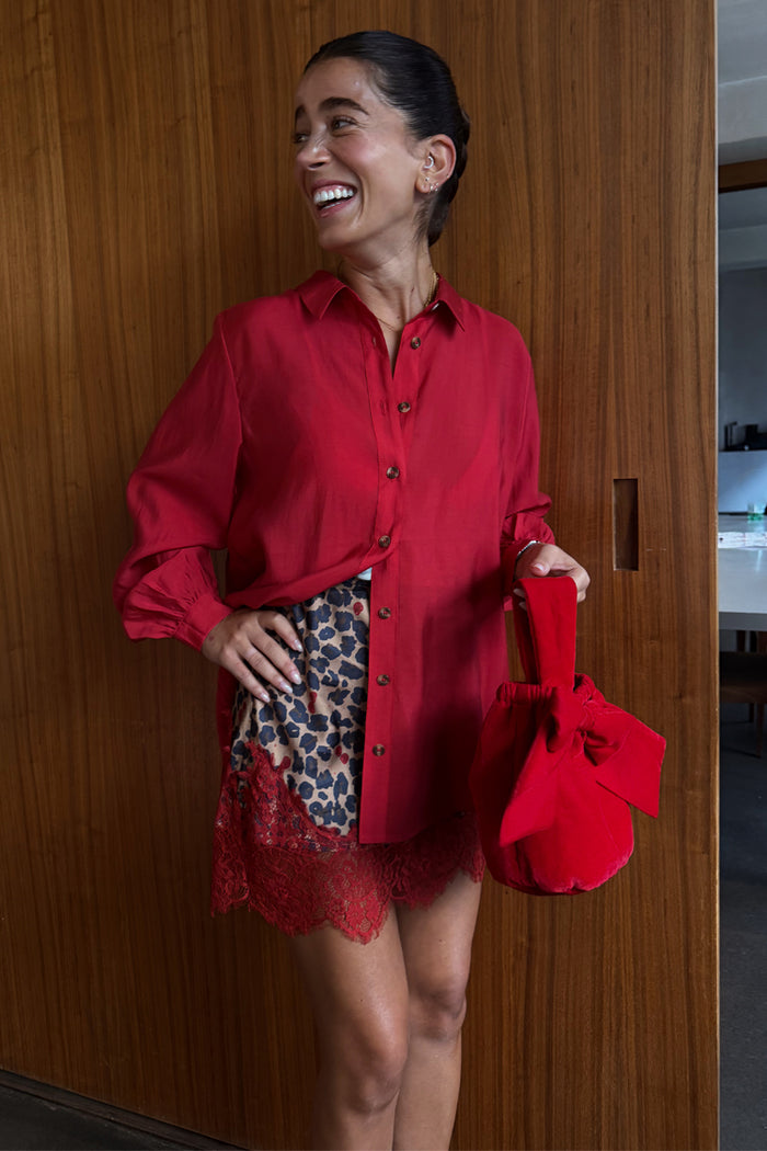 Cherry Red Miley Shirt featuring blouson sleeves and tortoise buttons, styled with a leopard-print lace skirt.