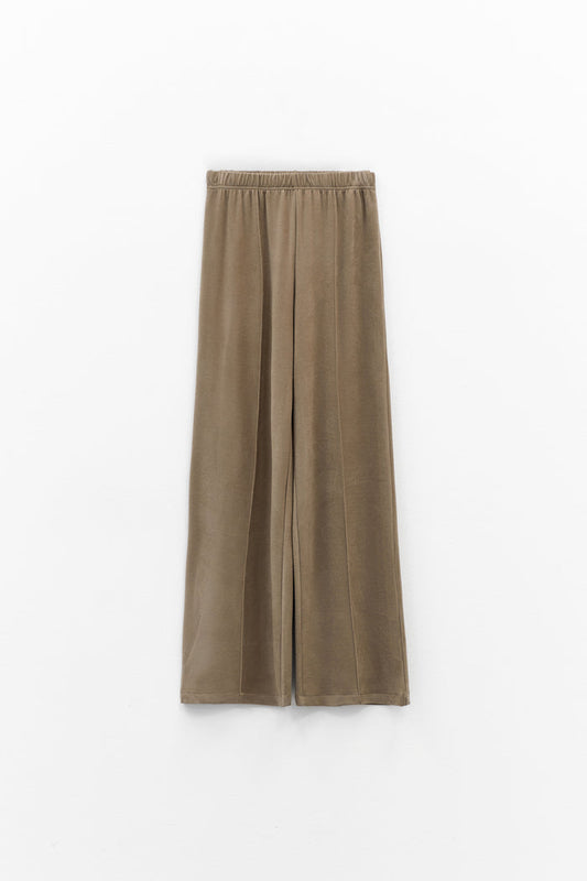 The ELEH - THE SCALA PULL ON SWEATPANT TROUSER by ELEH is a pair of loose-fitting, light brown, velvety pull-on trousers with an elastic waistband, shown against a plain white background.