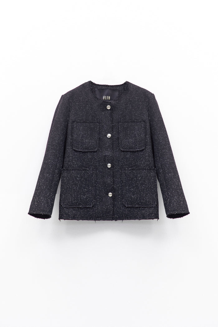 A person wears the ELEH - TWEED JACKET by ELEH, featuring textured black fabric and large front pockets, paired with dark pants and a black clutch with silver chain, against a white background.