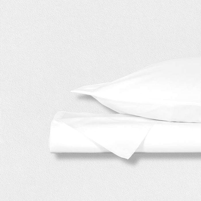 The FEARRINGTON LIFESTYLE BEDDING COLLECTION - FRETTE PILLOWCASES S4 by Frette North America features luxury white cotton sateen pillowcases, elegantly bundled with a black and white striped ribbon and finished with a "Fearrington" tag.