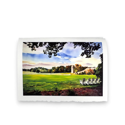 The FEARRINGTON SIGNATURE COLLECTION "CALM AFTER STORM" watercolor greeting card by PICTURE SALON captures a green lawn, silo, and white Adirondack chairs under leafy branches and blue sky—ideal for premium cardstock cards.