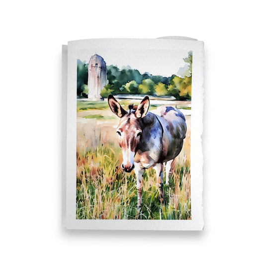 The FEARRINGTON SIGNATURE COLLECTION - WATERCOLOR GREETING CARD "JASPER" by PICTURE SALON features a watercolor donkey in tall grass with trees and a stone structure, perfect for textured paper greeting cards.