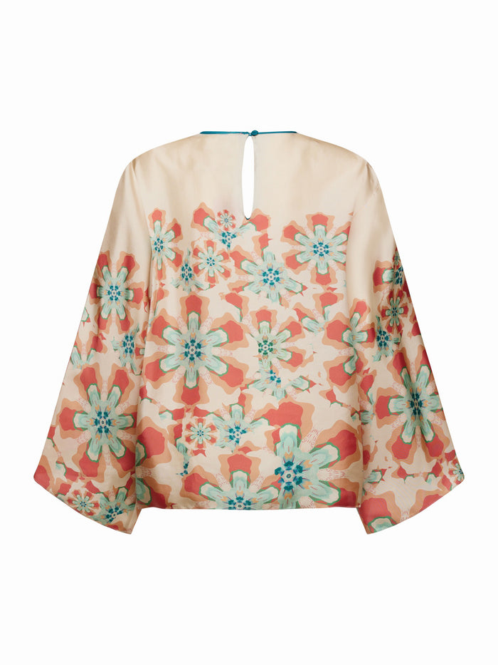 The FRANCO FERRARI - WIDE SLEEVE CORAL BLOUSE features a flowy, lightweight silk design with a floral print in teal, orange, and beige. Perfect for vacation dressing, it has a slightly sheer fabric with a round neckline and back button closure.