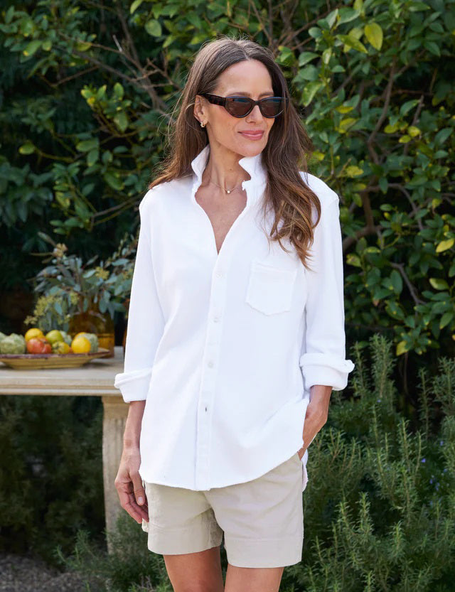 The FRANK & EILEEN Eileen Relaxed Button Up in Triple Fleece White features long sleeves, a single chest pocket, rolled cuffs, and a curved hem, shown against a white background.