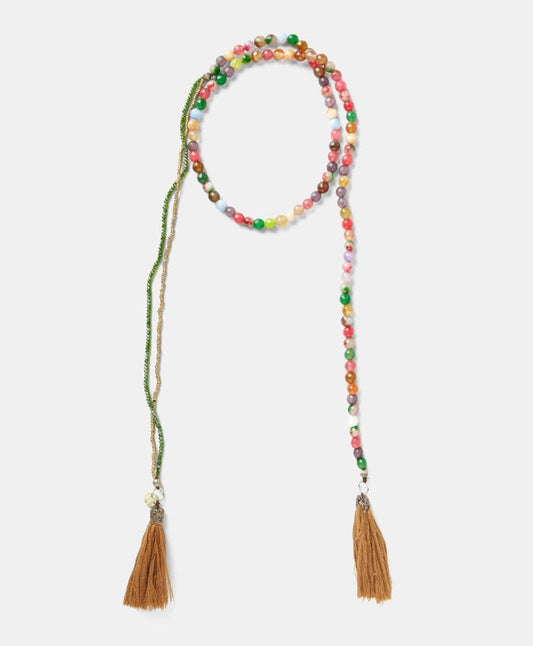 The MOMONI - NOEL NECKLACE by MOMONI features colorful round glass beads and two brown cotton tassels at each end, shown against a white background.