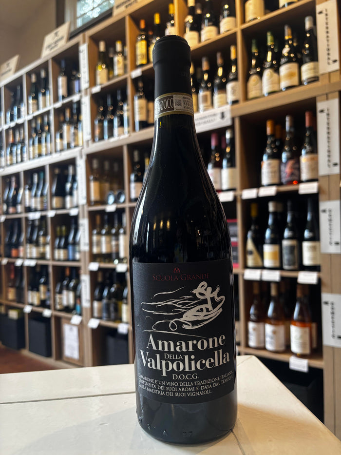 A bottle of SCUOLA GRANDE AMARONE 2020 by WINE: FREEDOM BEVERAGE, Veneto wine made with appassimento. The black label with white text and a gondola is shown upright against a white background.