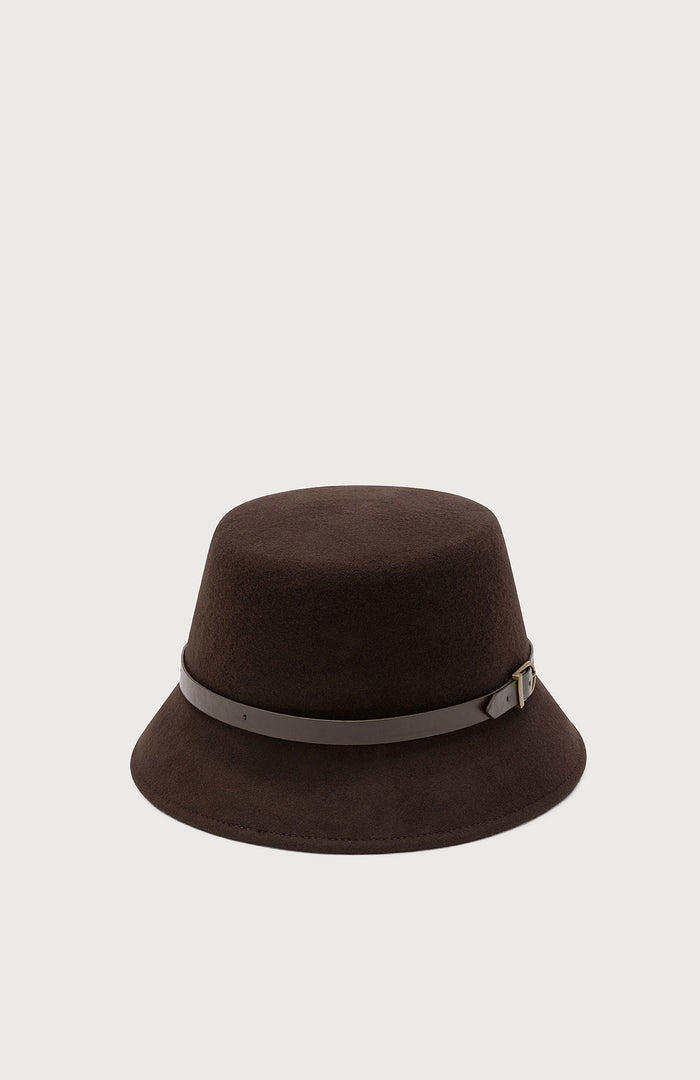 The SEVENTY VENEZIA - CLOCHE HAT by SEVENTY is a dark brown felt hat with a wide brim, accented by a thin taupe leather strap and small metal buckle around the crown, shown against a plain light background.